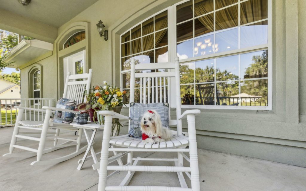 Lil' Dottie inspecting the comfort of a rocking chair on the porch of 166 Mount Royal Avenue in Crescent City, Florida.