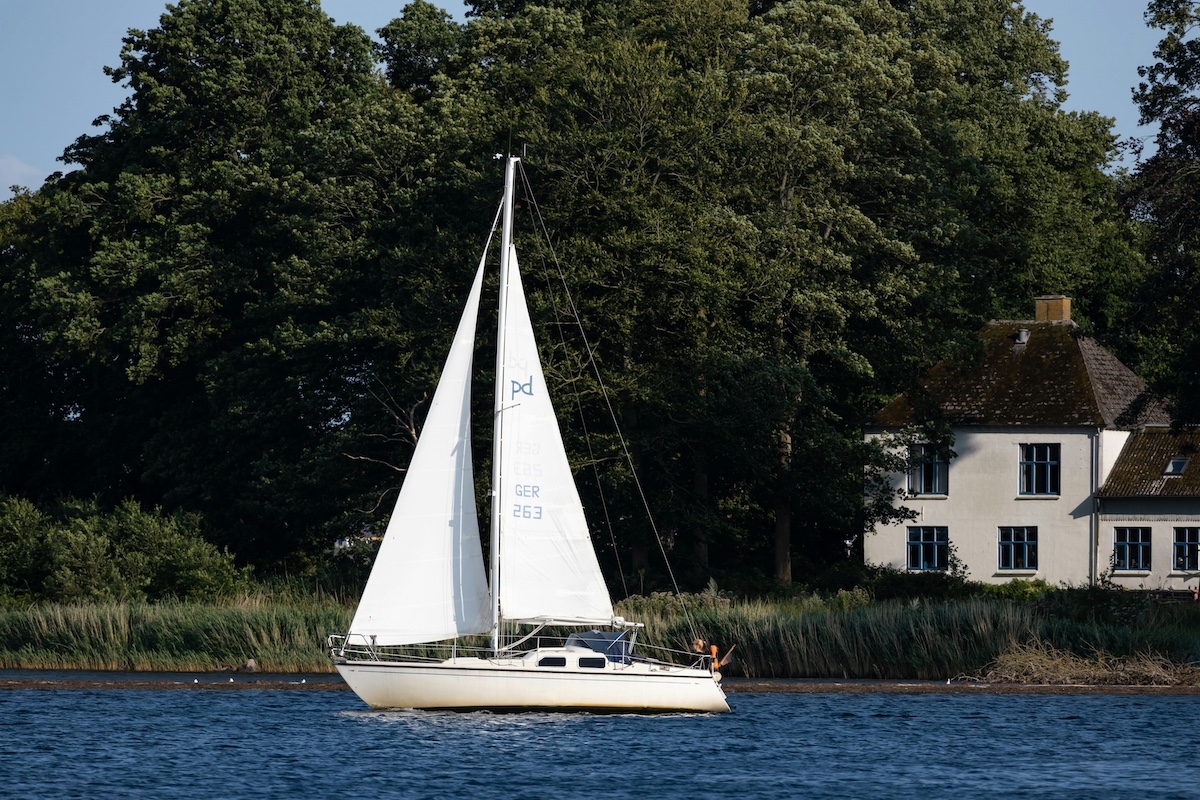 Sailboat passing by waterfront home in Palatka Florida.